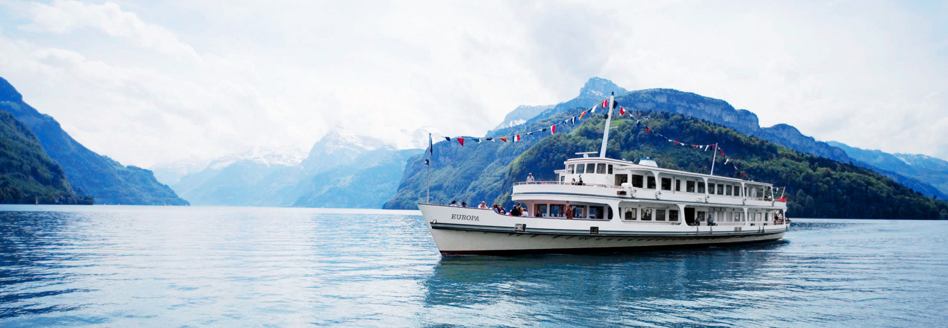Le bateau à moteur Europa avec des drapeaux fixes lors d'un voyage sur le lac des Quatre-Cantons.