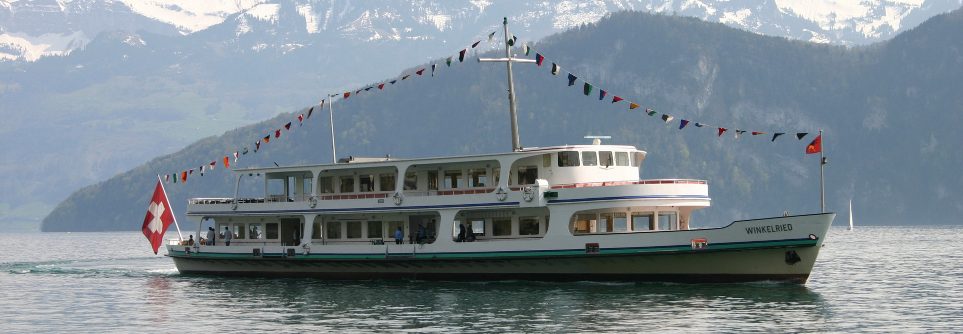 During a cruise on Lake Lucerne, fixed flags adorn the motor ship Winkelried.