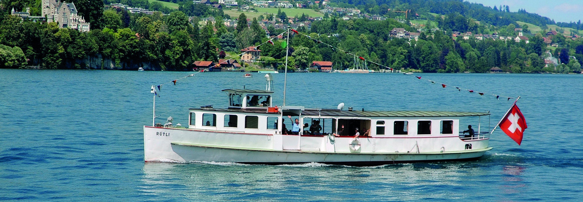 Le bateau à moteur Rütli navigue sur le lac des Quatre-Cantons par beau temps.