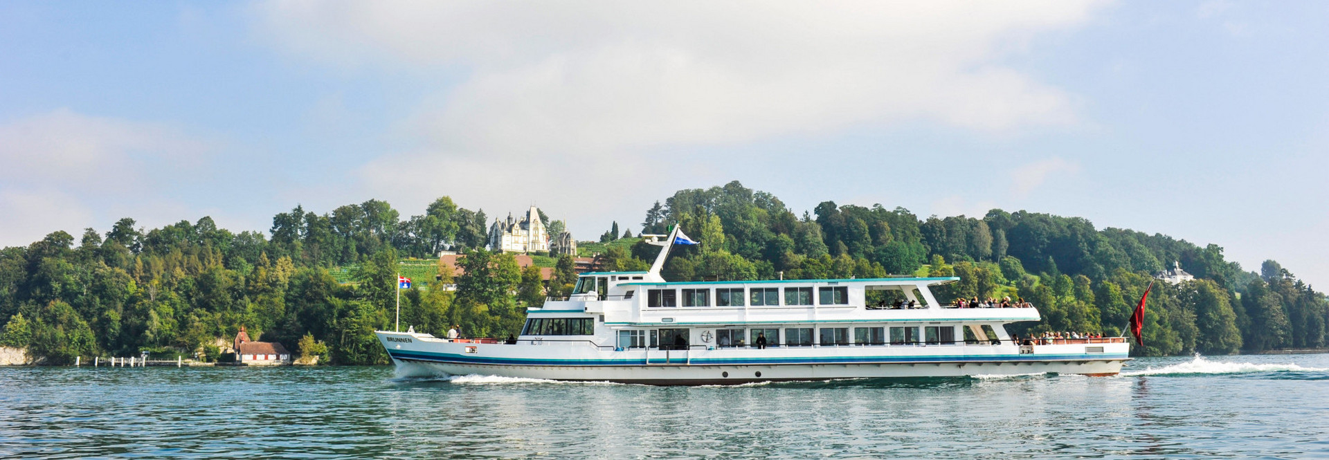 The motor vessel Brunnen sails on Lake Lucerne in sunny weather.