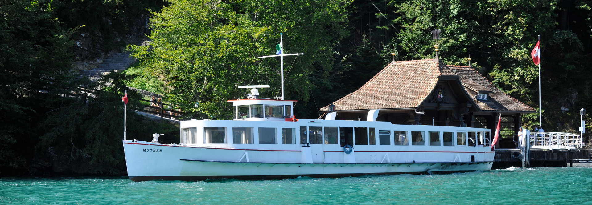 The motor vessel Mythen sails on Lake Lucerne in sunny weather.